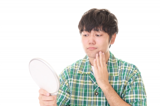化粧水をつけて鏡で確認する男性