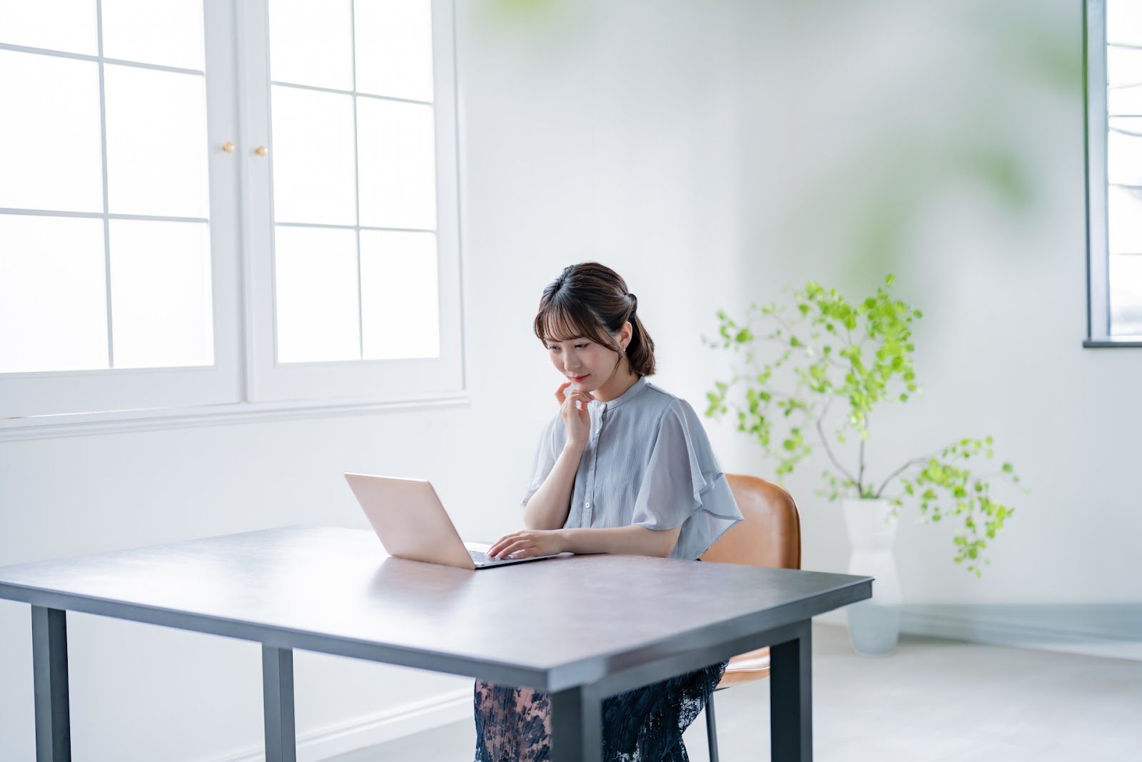 PCを見て悩む女性
