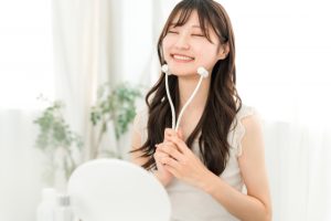 美顔ローラーで顔のリンパマッサージをする女性